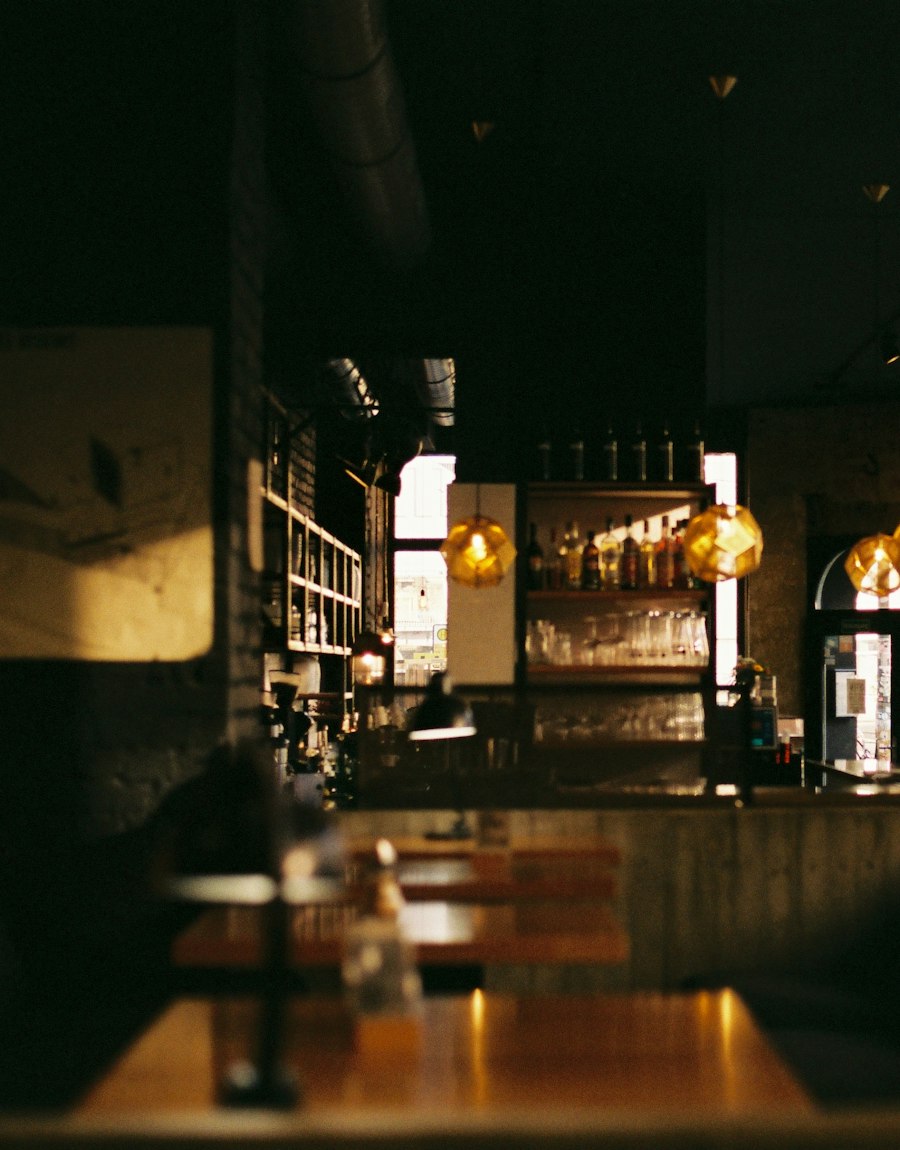 La salle en soirée, bar en bois sombre et lumières tamisées