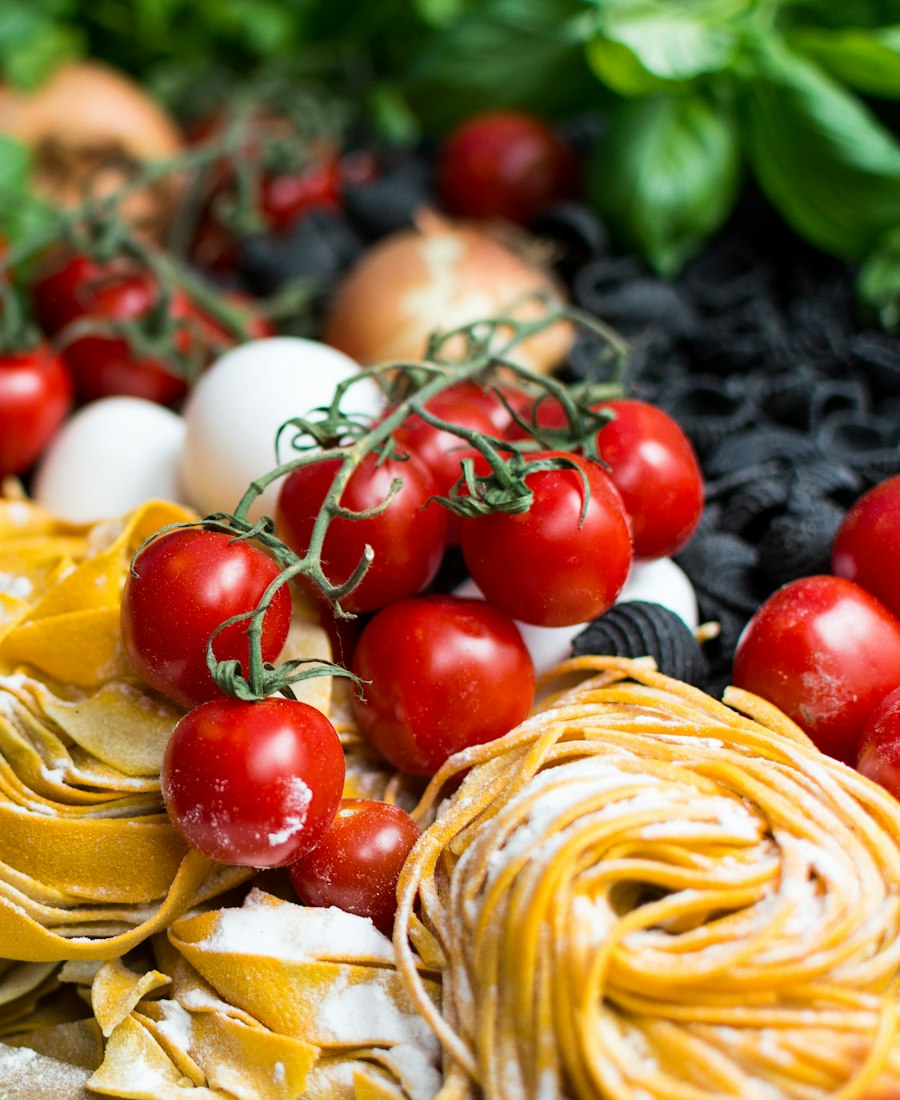 Tomates cerises en grappe, pâtes fraîches et basilic sur un plan de travail