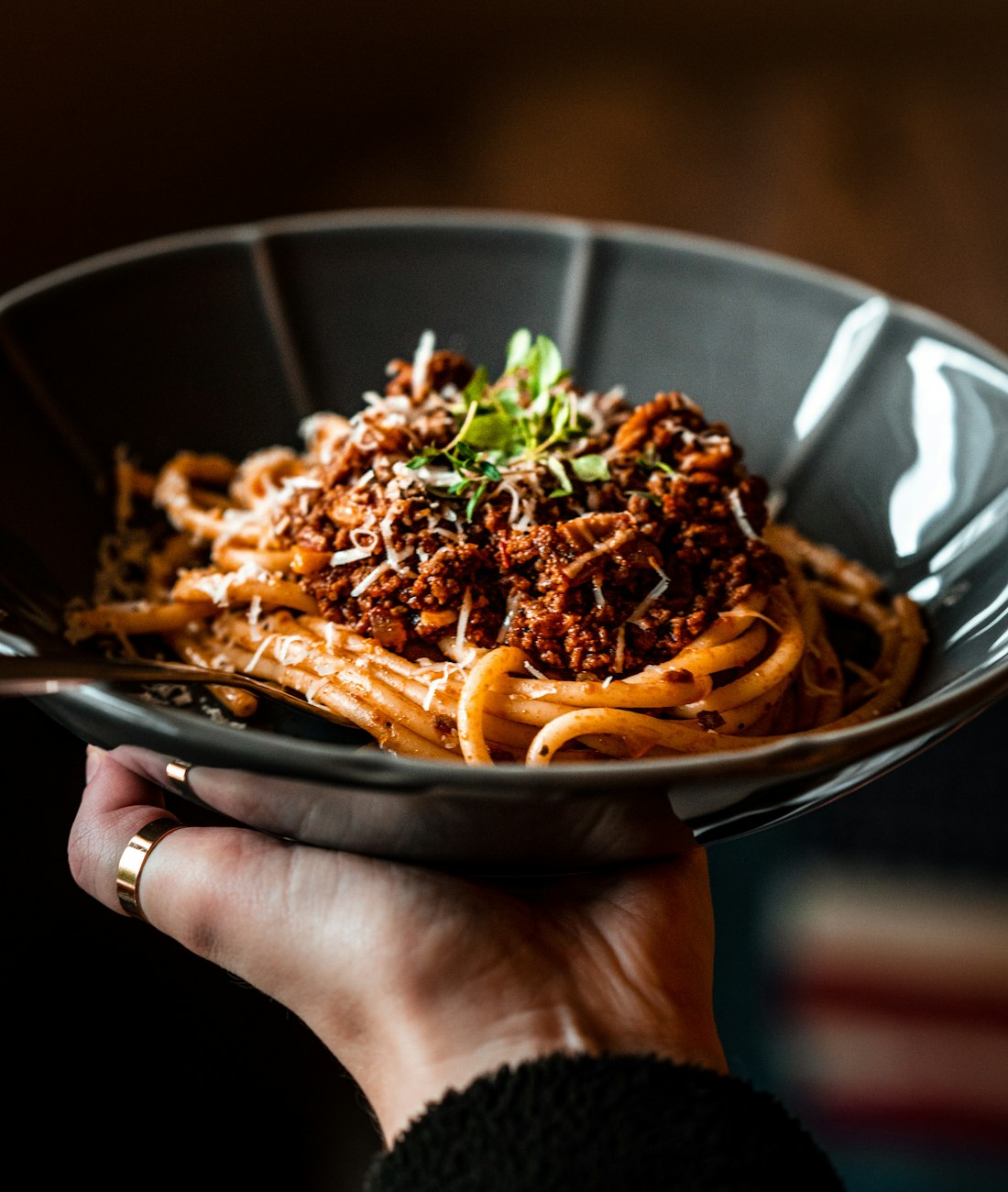 Assiette de tagliatelle au ragù bolognese parsemées de parmesan