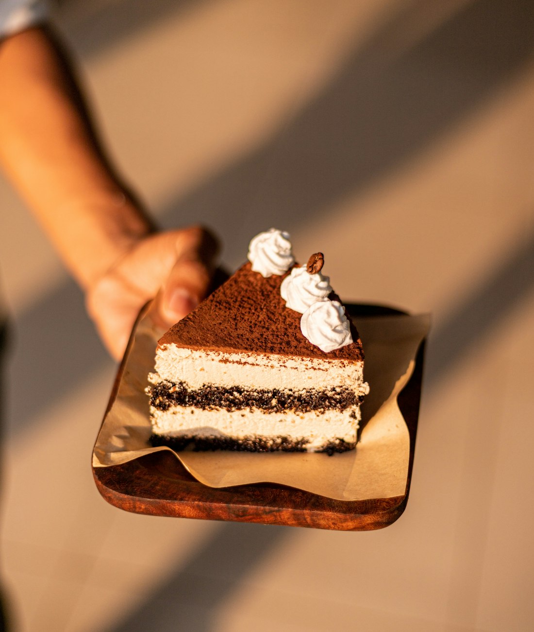 Part de tiramisù aux couches de mascarpone et de biscuit, saupoudrée de cacao